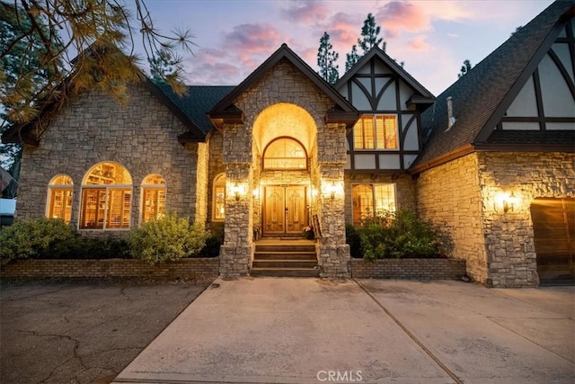 114 Starvation Flats Rd, Big Bear Lake, CA 92315 - exterior entry at dusk featuring stone siding and stucco siding