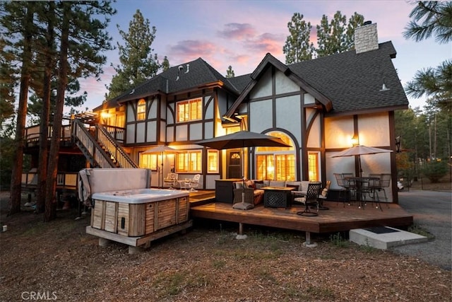 114 Starvation Flats Rd, Big Bear Lake, CA 92315 - back of house at dusk featuring outdoor lounge area, a shingled roof, stucco siding, and a wooden deck