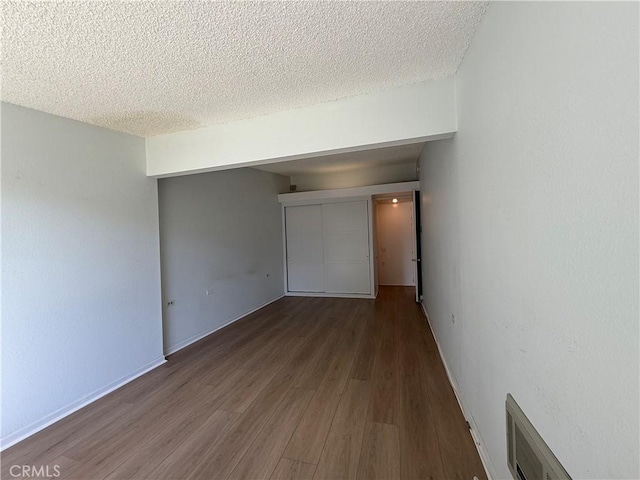 1533 Merion Way Unit 26K, Seal Beach, CA 90740 - unfurnished bedroom featuring wood finished floors and a textured ceiling