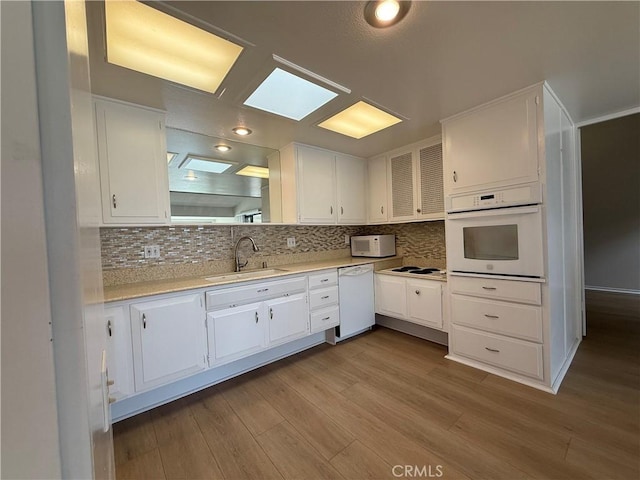 1533 Merion Way Unit 26K, Seal Beach, CA 90740 - kitchen with white appliances, white cabinetry, and decorative backsplash