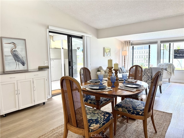 1533 Merion Way Unit 26K, Seal Beach, CA 90740 - dining room with light wood-type flooring, a textured ceiling, and lofted ceiling