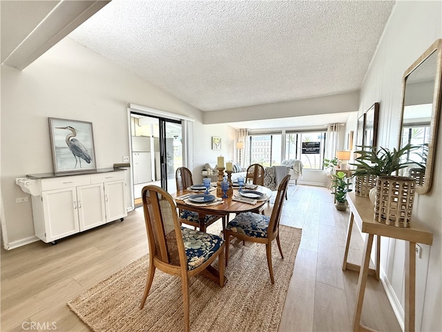 1533 Merion Way Unit 26K, Seal Beach, CA 90740 - dining space featuring a textured ceiling, light wood-style floors, and vaulted ceiling