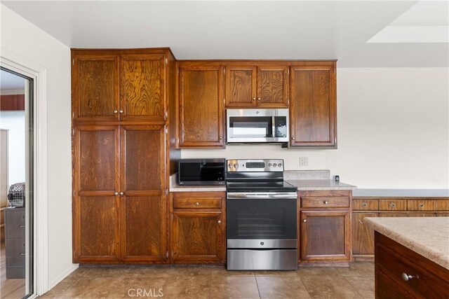 26231 Avenida Calidad, Mission Viejo, CA 92691 - kitchen with stainless steel appliances, light countertops, and brown cabinetry