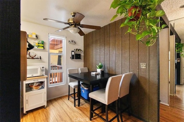 1000 W Macarthur Blvd Unit 44, Santa Ana, CA 92707 - dining room featuring wood finished floors, a ceiling fan, and wood walls