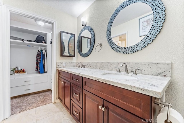 3372 Buckingham Rd, Chino Hills, CA 91709 - full bathroom with double vanity, a textured wall, a walk in closet, and tile patterned floors
