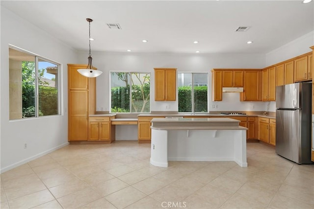 69635 Valle De Costa, Cathedral City, CA 92234 - kitchen with freestanding refrigerator, under cabinet range hood, light countertops, stovetop, and a center island