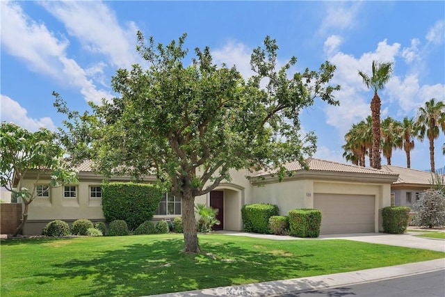 69635 Valle De Costa, Cathedral City, CA 92234 - view of front of home with a tile roof, a garage, concrete driveway, a front lawn, and stucco siding