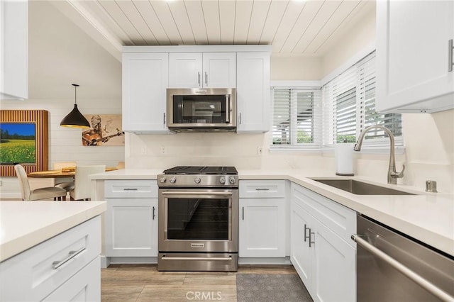 4735 Sunny Hills Rd, Oceanside, CA 92056 - kitchen featuring appliances with stainless steel finishes, a sink, white cabinets, light wood finished floors, and light countertops