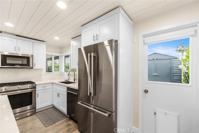 4735 Sunny Hills Rd, Oceanside, CA 92056 - kitchen with appliances with stainless steel finishes, a sink, white cabinets, light countertops, and recessed lighting