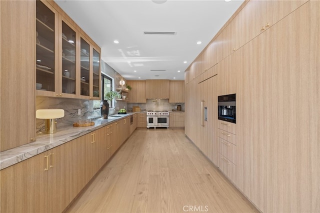 721 Wilson Ct, Burbank, CA 91501 - kitchen with range with two ovens, modern cabinets, light brown cabinets, light wood finished floors, and backsplash