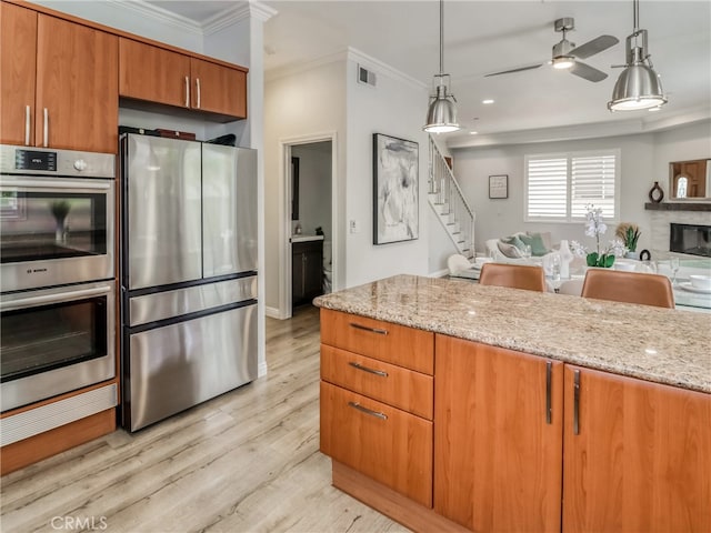 2223 Grant Ave Unit C, Redondo Beach, CA 90278 - kitchen with appliances with stainless steel finishes, crown molding, open floor plan, light stone counters, and brown cabinets