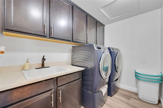 34253 Mazarine Dr, Temecula, CA 92592 - laundry area featuring washer and dryer, cabinet space, light wood-type flooring, and baseboards