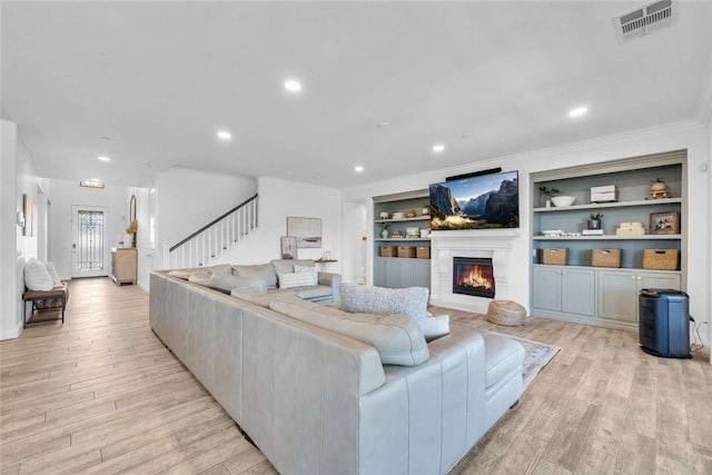34253 Mazarine Dr, Temecula, CA 92592 - living room with stairway, light wood-type flooring, a glass covered fireplace, recessed lighting, and crown molding