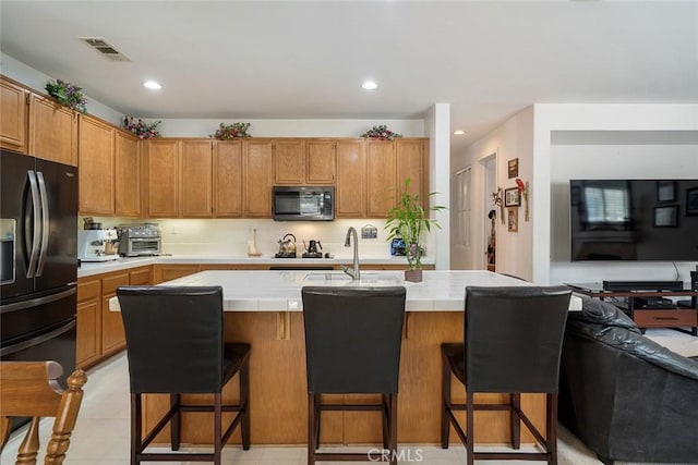 31332 Gatehouse Ct, Murrieta, CA 92563 - kitchen with black appliances, tile countertops, a sink, a breakfast bar area, and recessed lighting