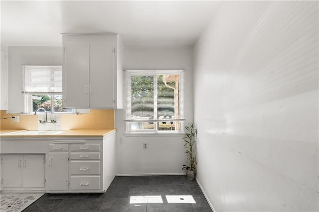 44246 Foxton Ave, Lancaster, CA 93535 - kitchen featuring a sink, backsplash, white cabinets, and baseboards