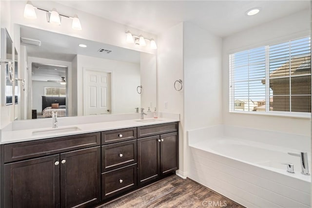 37436 Umbrella, Palmdale, CA 93551 - bathroom featuring double vanity, wood finished floors, a garden tub, connected bathroom, and recessed lighting