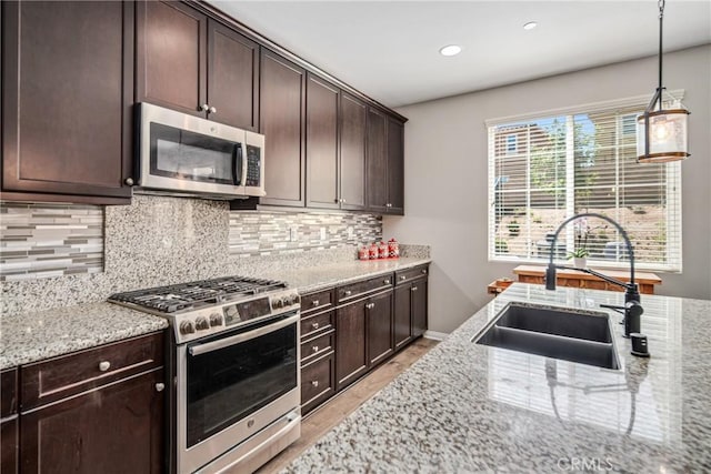 37436 Umbrella, Palmdale, CA 93551 - kitchen featuring appliances with stainless steel finishes, a sink, tasteful backsplash, light stone countertops, and dark brown cabinetry
