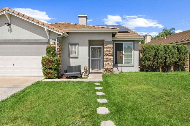 5191 Westerfield St, Jurupa Valley, CA 92509 - single story home with stucco siding, solar panels, a front lawn, a chimney, and an attached garage