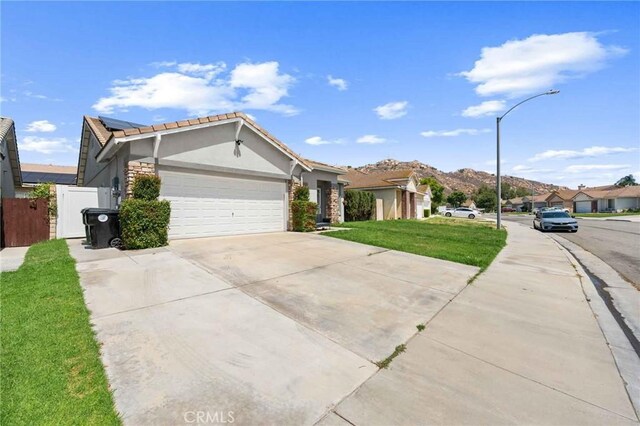 5191 Westerfield St, Jurupa Valley, CA 92509 - ranch-style home featuring stucco siding, a garage, driveway, a tiled roof, and stone siding