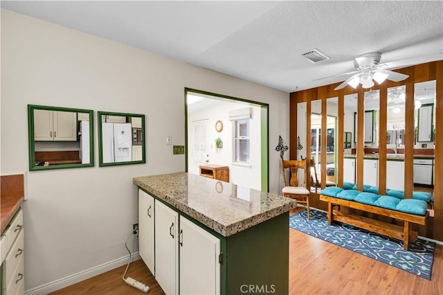 7608 Shawnee Trl, Yucca Valley, CA 92284 - kitchen featuring light wood-style floors, a peninsula, white refrigerator with ice dispenser, white cabinets, and ceiling fan