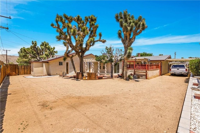 7608 Shawnee Trl, Yucca Valley, CA 92284 - back of property featuring a carport, stucco siding, and driveway