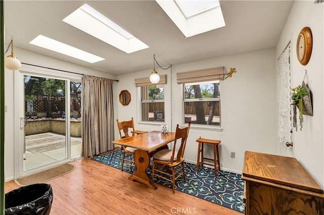 7608 Shawnee Trl, Yucca Valley, CA 92284 - dining room featuring a skylight, wood finished floors, plenty of natural light, and baseboards