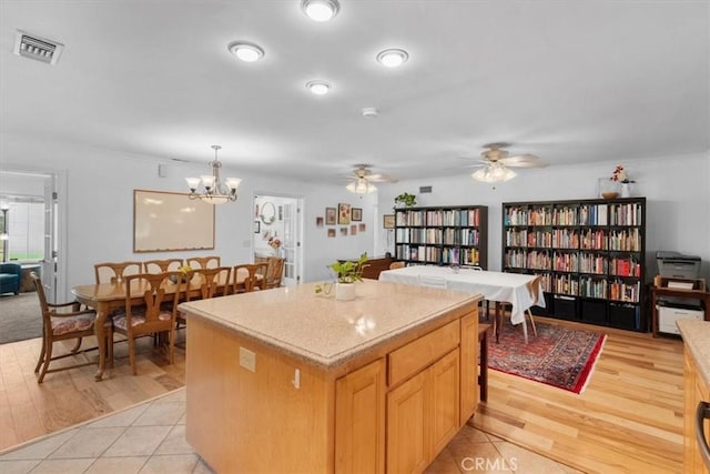 1626 S Boulder Ave, Ontario, CA 91762 - kitchen featuring light countertops, a center island, hanging light fixtures, ceiling fan, and a chandelier