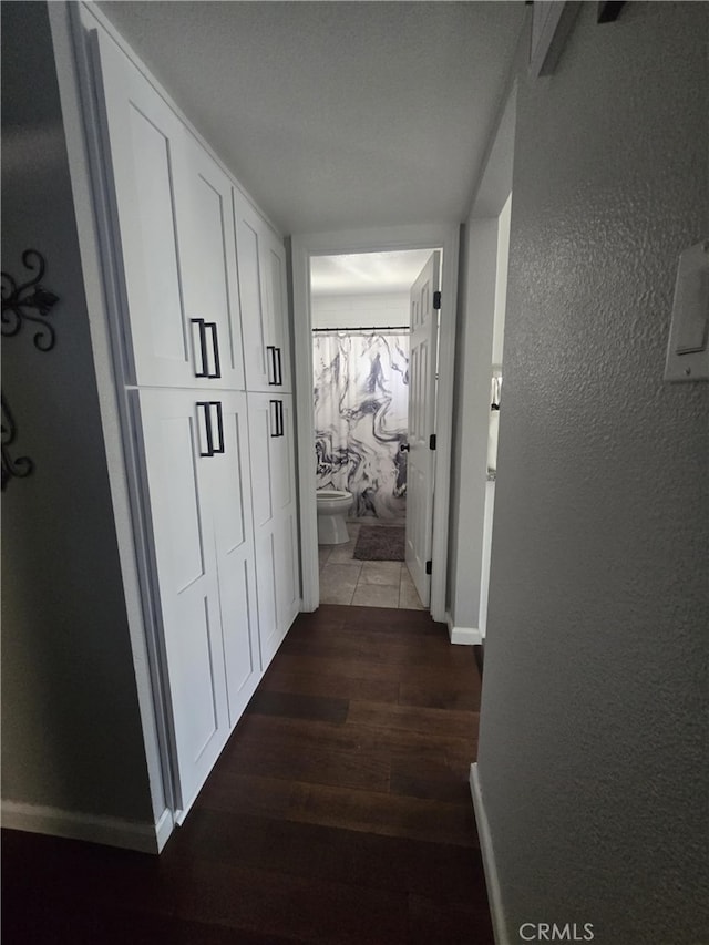 1212 Gen Ct, Barstow, CA 92311 - hall featuring dark wood-style floors, a textured wall, and baseboards