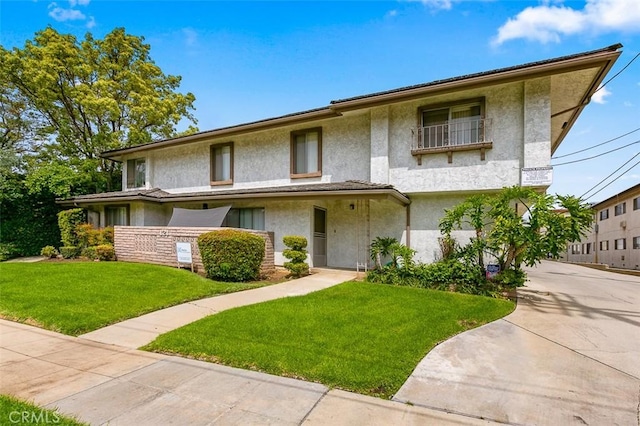 121 E Live Oak St, San Gabriel, CA 91776 - view of front of house with stucco siding, a front yard, and driveway