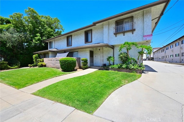 121 E Live Oak St, San Gabriel, CA 91776 - view of front facade with stucco siding, a front yard, and driveway