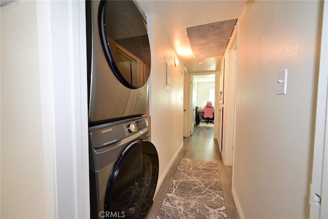 121 E Live Oak St, San Gabriel, CA 91776 - laundry room with stacked washing machine and dryer, wood finished floors, and baseboards