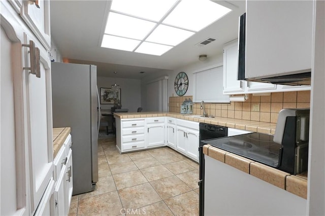 5030 Cardiff Ln, Atwater, CA 95301 - kitchen with freestanding refrigerator, white cabinetry, a peninsula, tasteful backsplash, and stove