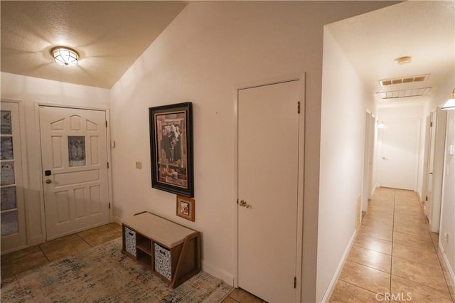 5030 Cardiff Ln, Atwater, CA 95301 - corridor featuring light tile patterned floors, vaulted ceiling, and a textured ceiling