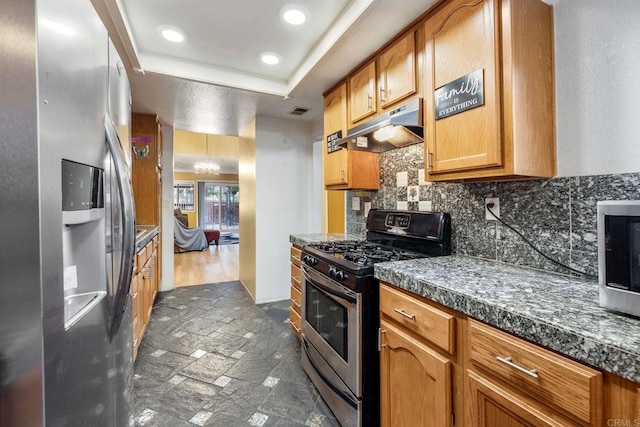 1518 Goldrush Way, Oceanside, CA 92057 - kitchen with stainless steel appliances, under cabinet range hood, decorative backsplash, brown cabinetry, and a raised ceiling