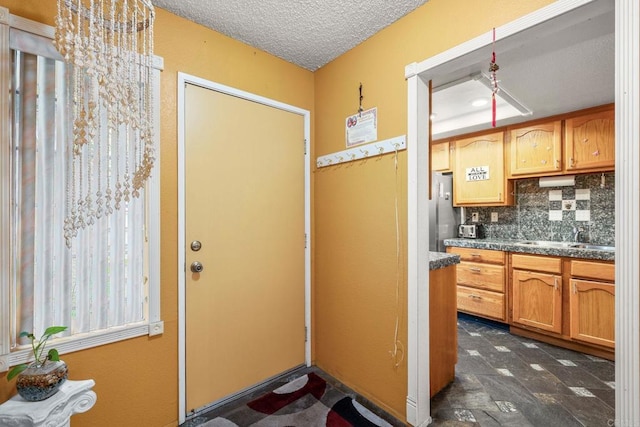 1518 Goldrush Way, Oceanside, CA 92057 - kitchen featuring freestanding refrigerator, decorative backsplash, dark countertops, a textured ceiling, and a chandelier