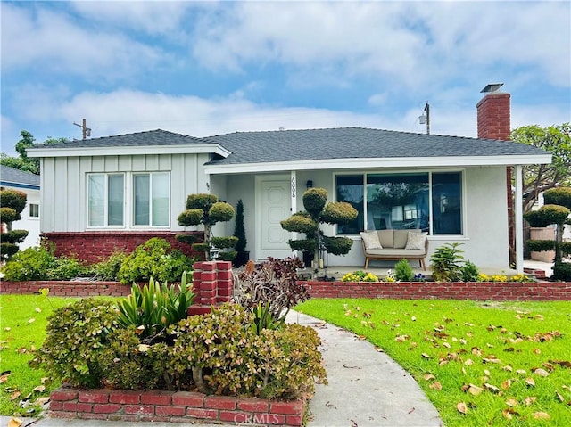 6008 Amos Ave, Lakewood, CA 90712 - bungalow-style house with board and batten siding, a front lawn, roof with shingles, a chimney, and brick siding