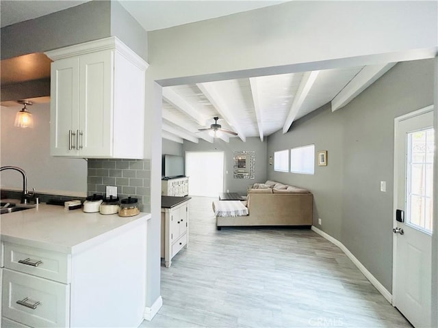 6008 Amos Ave, Lakewood, CA 90712 - kitchen featuring ceiling fan, beamed ceiling, light wood-type flooring, white cabinetry, and healthy amount of natural light