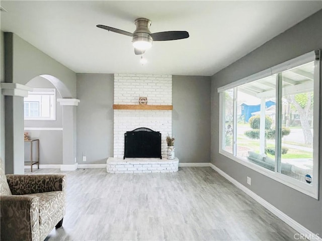 6008 Amos Ave, Lakewood, CA 90712 - unfurnished living room with a ceiling fan, wood finished floors, a fireplace, and arched walkways