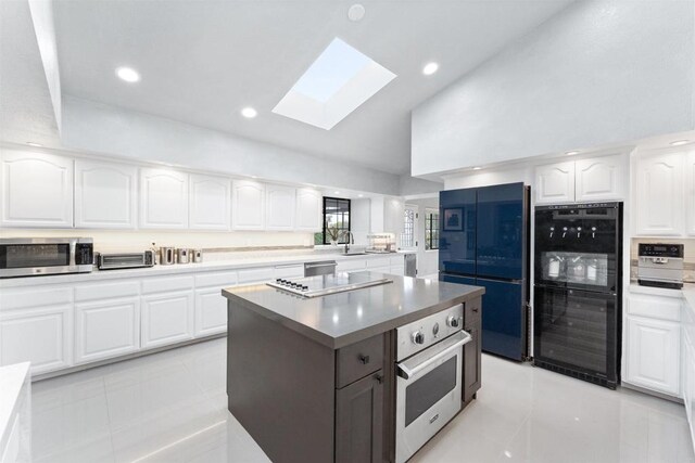 19 Gateview Dr, Fallbrook, CA 92028 - kitchen with stainless steel microwave, fridge, a skylight, wine cooler, and white cabinetry