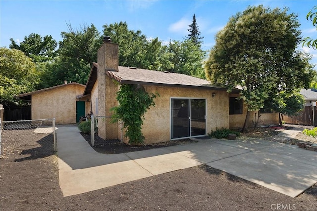 1018 Greenwich Dr, Chico, CA 95926 - back of property featuring a chimney, stucco siding, and a patio area