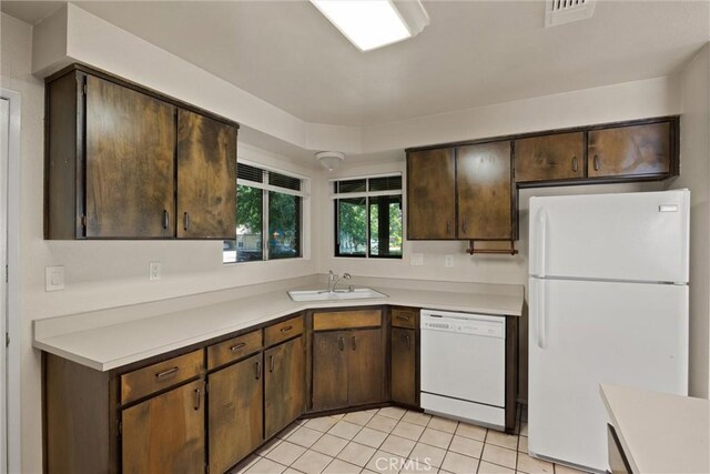 1018 Greenwich Dr, Chico, CA 95926 - kitchen featuring white appliances, a sink, light countertops, dark brown cabinetry, and light tile patterned floors
