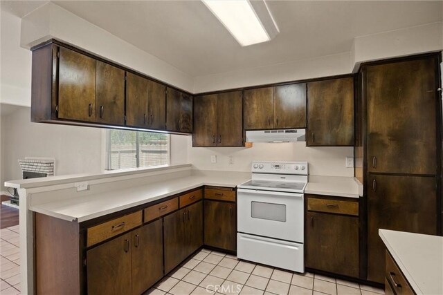 1018 Greenwich Dr, Chico, CA 95926 - kitchen featuring white electric range oven, under cabinet range hood, light tile patterned floors, and light countertops