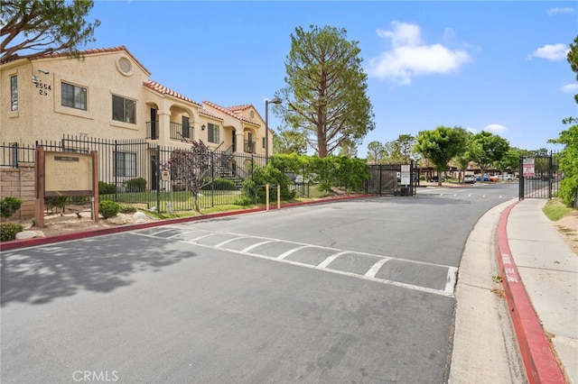 2554 Olive Dr Unit 38, Palmdale, CA 93550 - view of asphalt road featuring curbs, a gated entry, sidewalks, street lights, and a gate