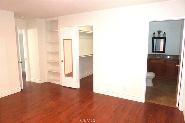 900 W Sierra Madre Ave Unit 184, Azusa, CA 91702 - unfurnished bedroom with a spacious closet, dark wood-type flooring, a sink, and baseboards