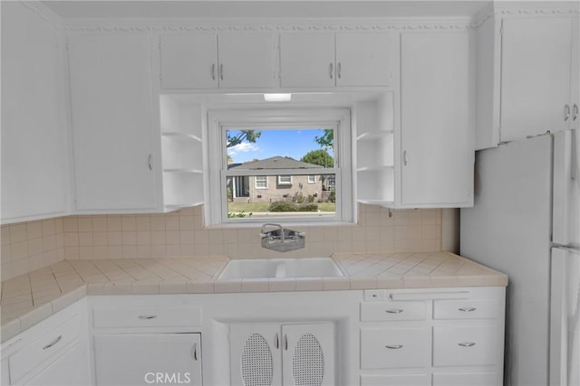11046 Howard St, Whittier, CA 90606 - kitchen featuring freestanding refrigerator, open shelves, white cabinetry, and decorative backsplash