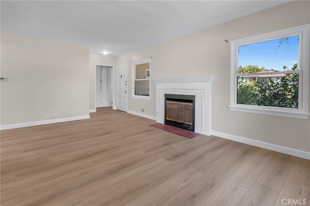 11046 Howard St, Whittier, CA 90606 - unfurnished living room featuring light wood-type flooring and a fireplace with flush hearth