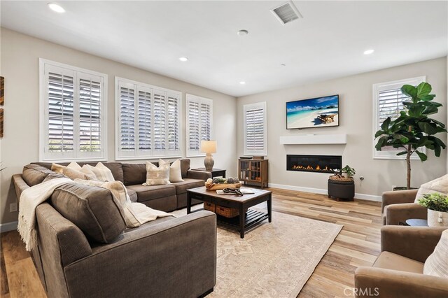 24 Granja Ct, Rancho Mission Viejo, CA 92694 - living area featuring wood finished floors, recessed lighting, and a glass covered fireplace
