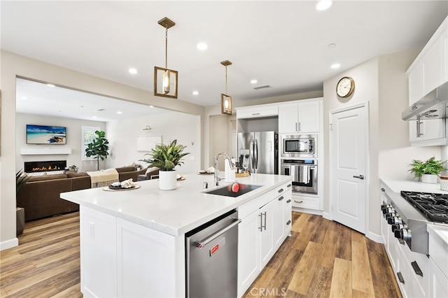 24 Granja Ct, Rancho Mission Viejo, CA 92694 - kitchen with stainless steel appliances, recessed lighting, light countertops, light wood finished floors, and white cabinetry