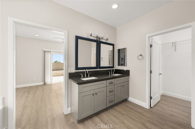 1239 Ansley Ln, Mentone, CA 92359 - full bathroom with wood finished floors, double vanity, a walk in closet, and recessed lighting