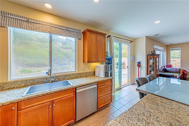 25238 Gloriso Ln, Stevenson Ranch, CA 91381 - kitchen with stainless steel dishwasher, a sink, brown cabinetry, light tile patterned floors, and recessed lighting